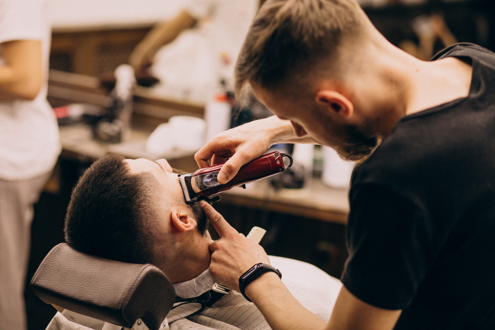 Imagem de um barbeiro cortando o cabelo de um cliente